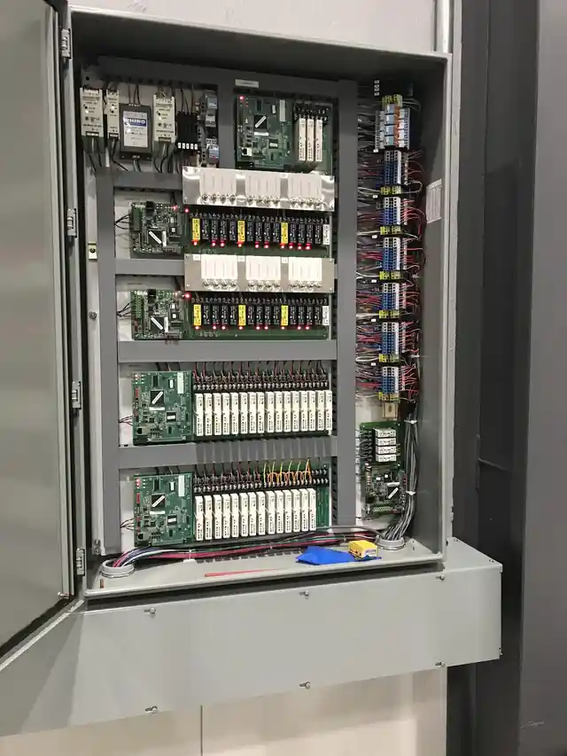 Open PLC control panel with I/O cards and labelled wiring