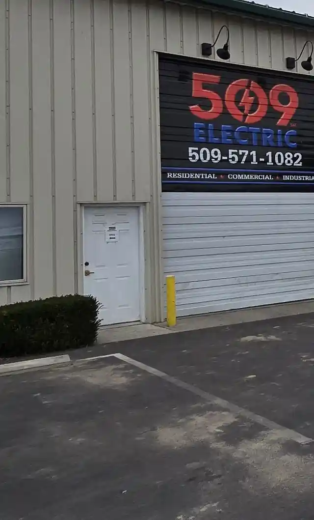 The 509 Electric shop roll-up door with the company sign and phone number